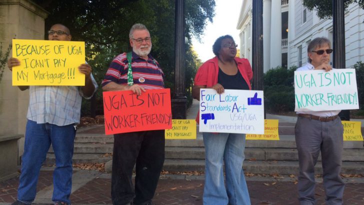 Employees stand outside UGA Arch to protest