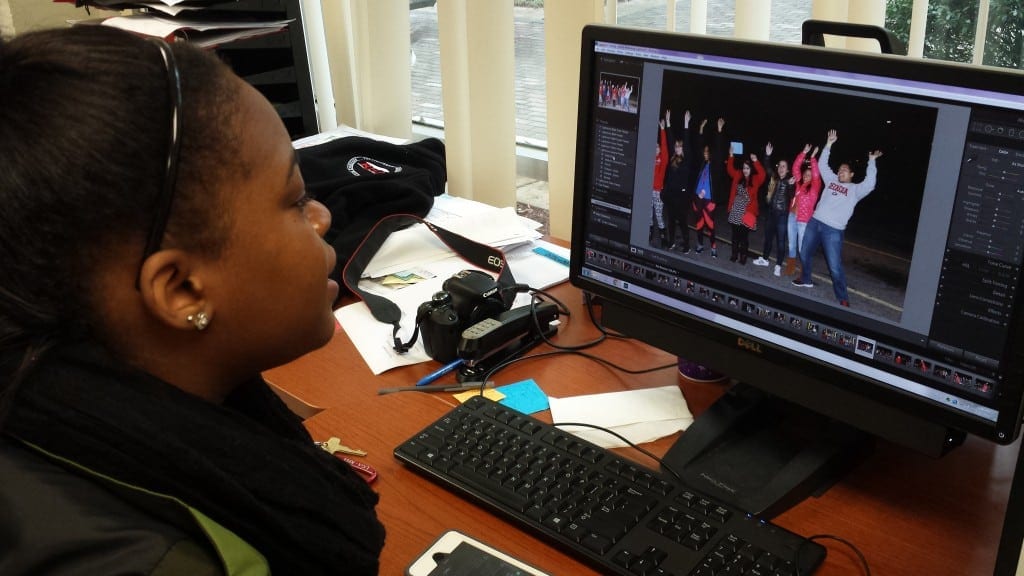 Juanne-Dae Thomas, historian for the Residence Hall Association (RHA) for the University of Georgia sits at computer in the RHA boardroom, editing photos taken at the Roll Bounce event hosted a week prior in Athens, Georgia, on Tuesday, Feb. 23, 2016. (Photo/ Precious D. Davis 