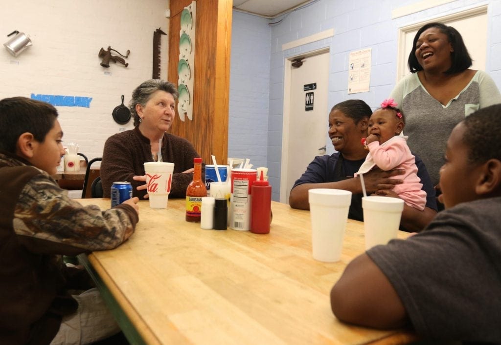 Theresa Kirkland, Tina Dunlap, Tasha Dunlap, Karly Dunlap, and Tyler Tucker all gather around a table at Dunlap's Down Home Cookin' in Waverly Hall, Georgia on the night of Saturday, February 27, 2016. It's been a busy day of serving barbecue to their loyal patrons, and with the calm of only having two tables occupied comes the storm of two entire fire departments that will soon descend upon the small restaurant. But for now, the calm of the cool late-winter night is refreshing and rewarding for the Dunlaps and their close friends. (Photo/Henry Taylor)