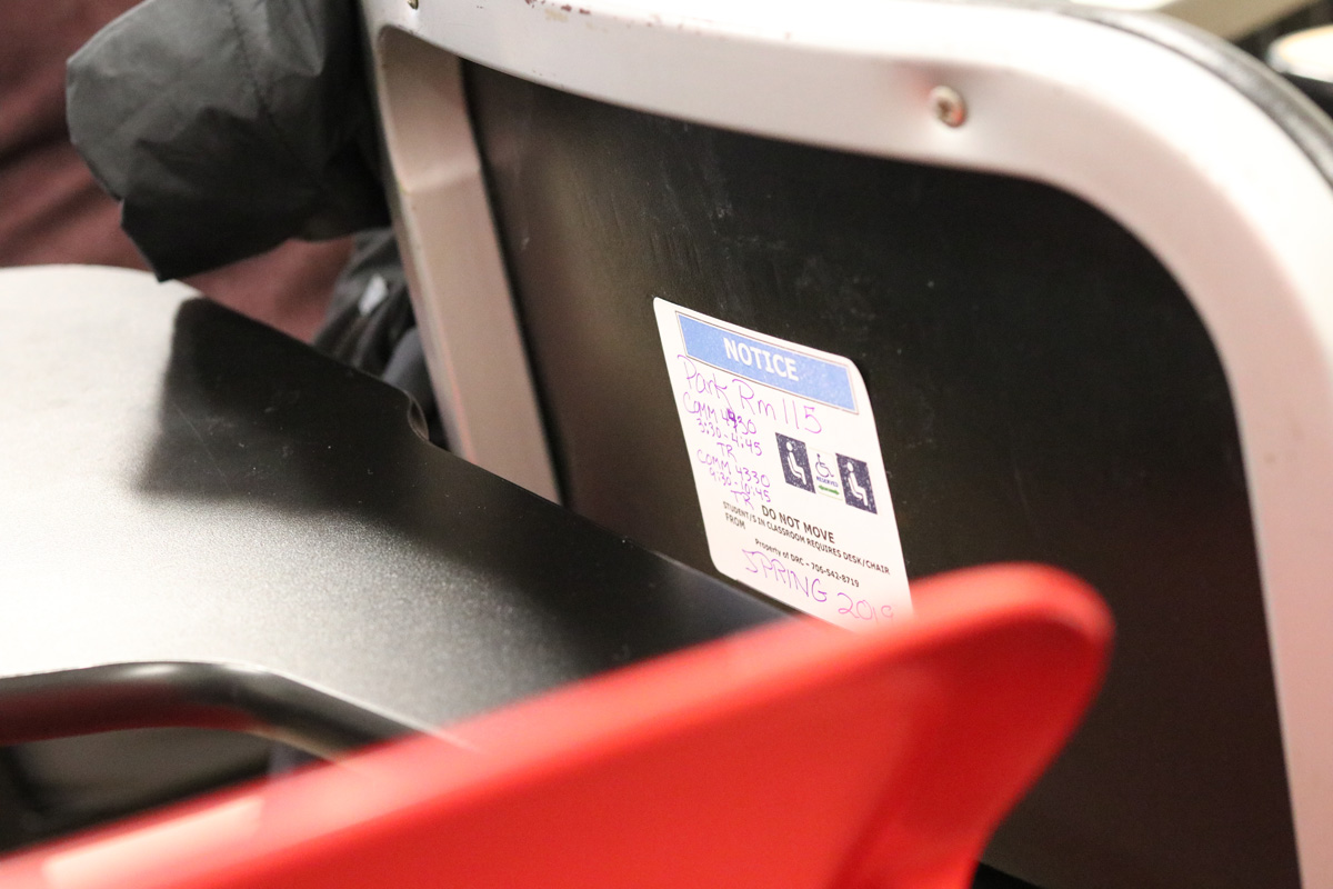 A black desk has a white and blue sticker placed in the middle.