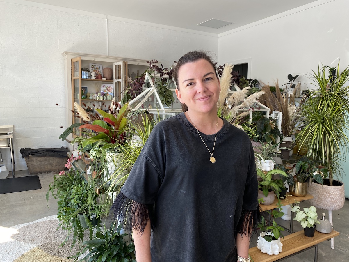 Designer Jade Joyner poses in front of a plant display in her shop.
