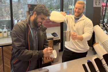 Prince Market managers Yash Patel (left) and Ryan Vetter (right) craft a beverage for a customer at the coffee bar, featuring a selection of Starbucks products.