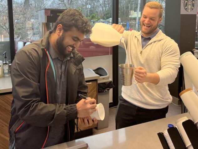 Prince Market managers Yash Patel (left) and Ryan Vetter (right) craft a beverage for a customer at the coffee bar, featuring a selection of Starbucks products.