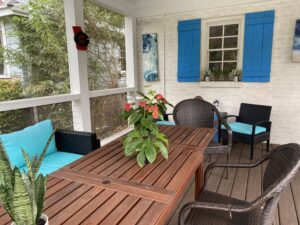 A porch with a table and chairs.