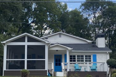 The exterior of a white house with a blue door.