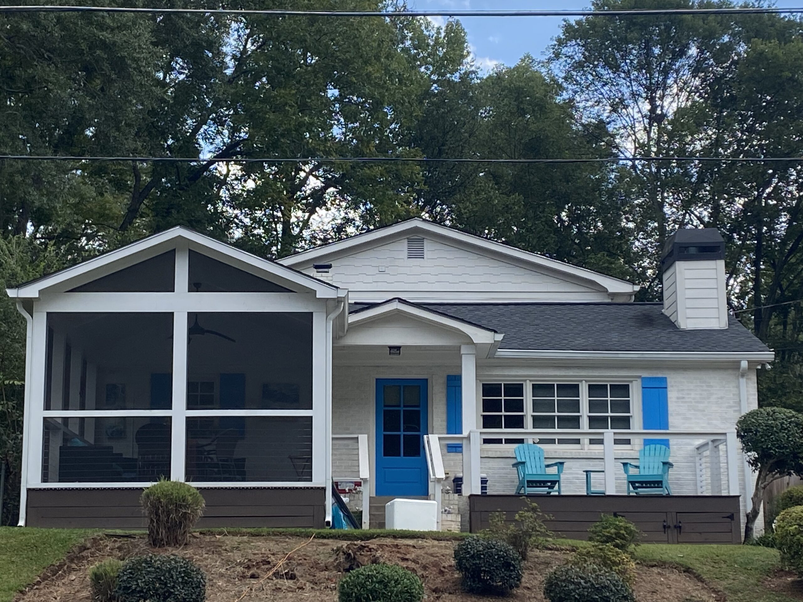 The exterior of a white house with a blue door.