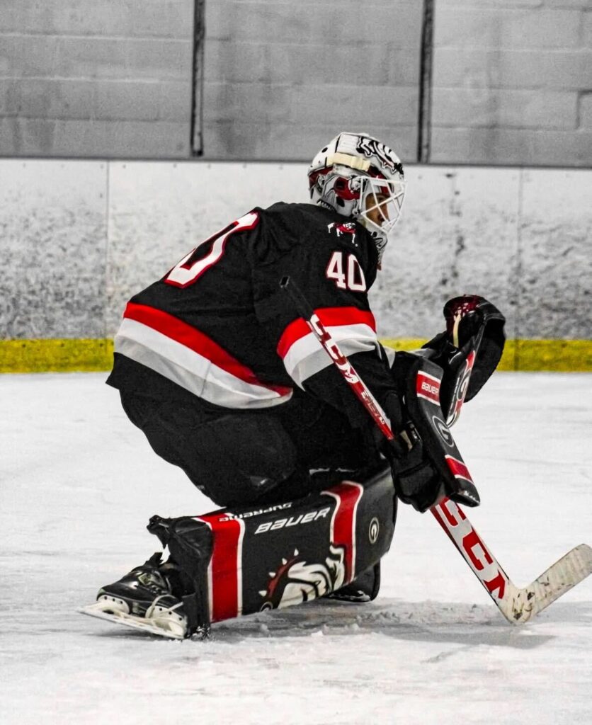 A hockey goalie catches a puck.