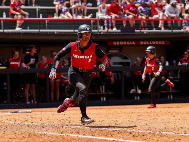 A softball player sprints for first base