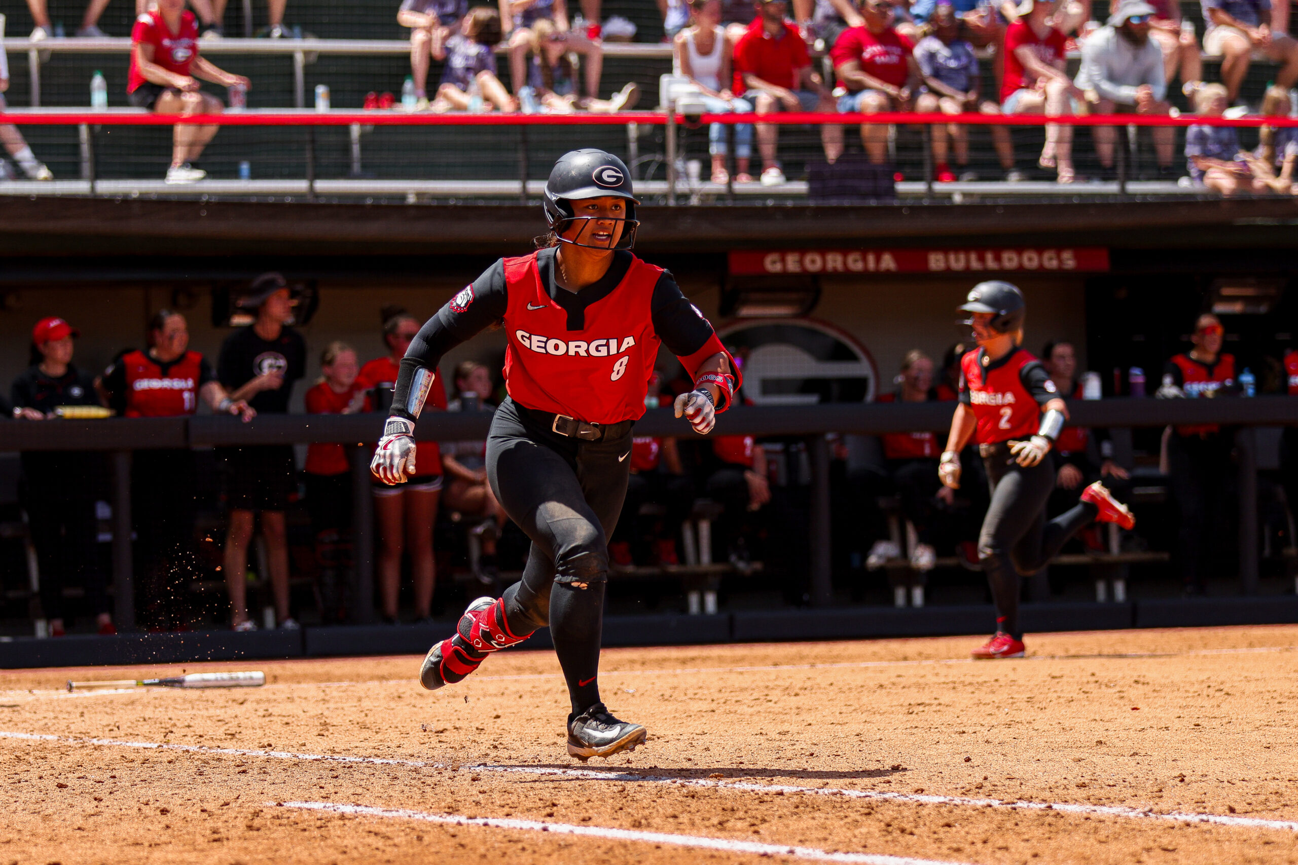 A softball player sprints for first base