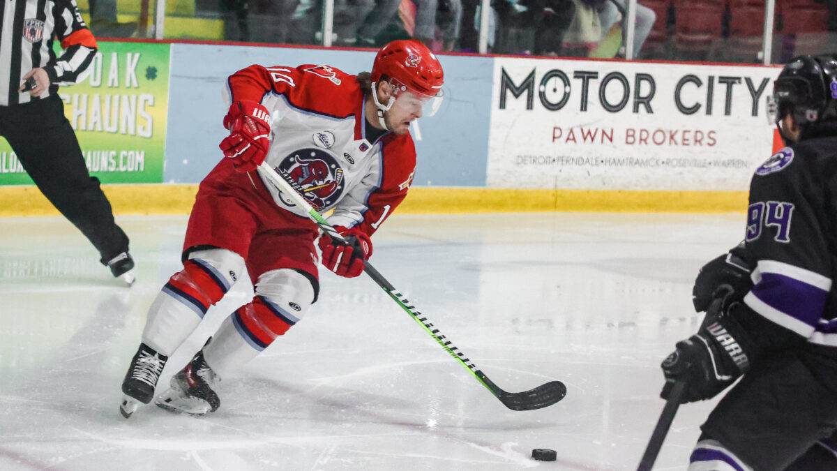 A hockey player controls the puck