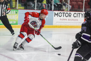 A hockey player controls the puck