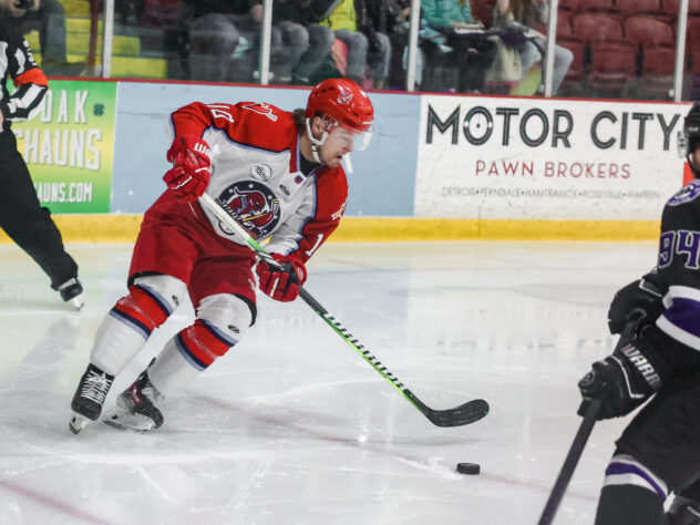 A hockey player controls the puck