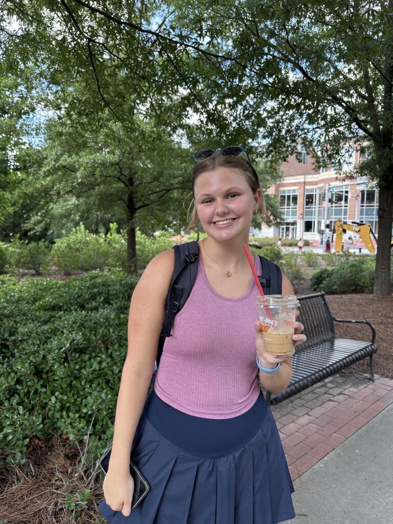 Student standing with coffee on UGA campus