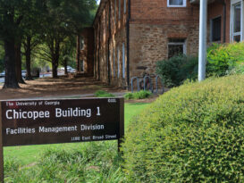 A sign in front of a building on the campus of the University of Georgia for the office of sustainability