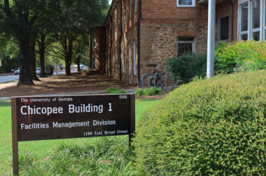 A sign in front of a building on the campus of the University of Georgia for the office of sustainability