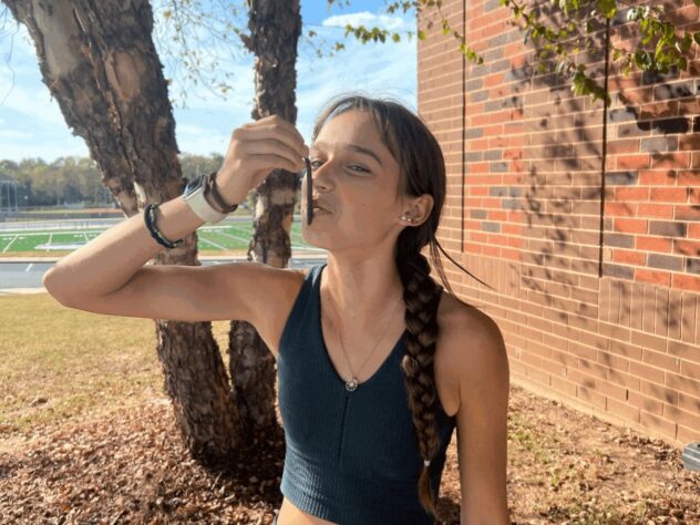 A high school runner kisses a rubber fishing worm for good luck.