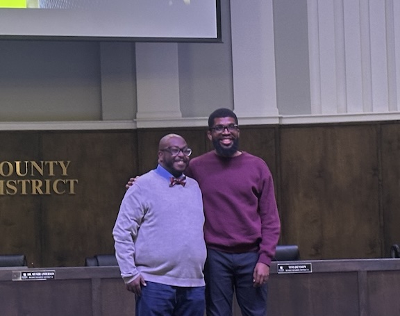 A father and son smiling at the camera