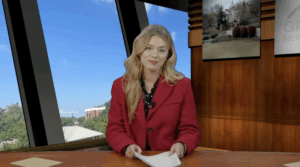 Anchor sits at a news desk