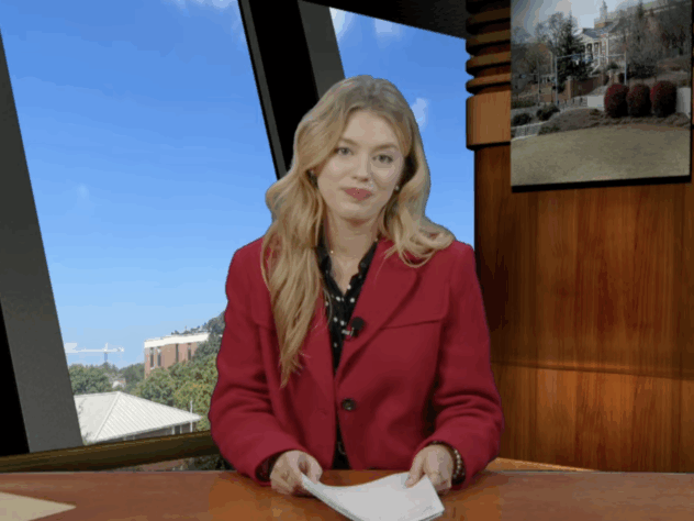 Anchor sits at a news desk