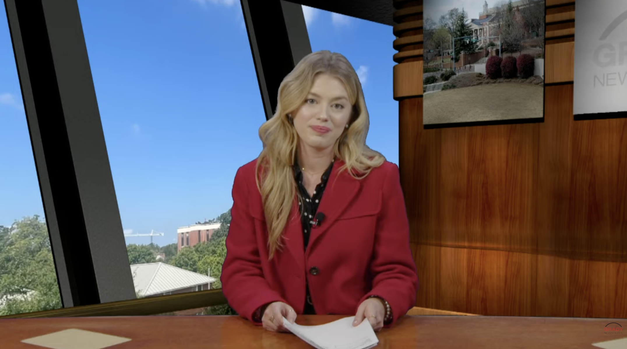 Anchor sits at a news desk