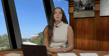 An anchor sitting behind a news desk