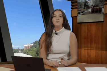 An anchor sitting behind a news desk