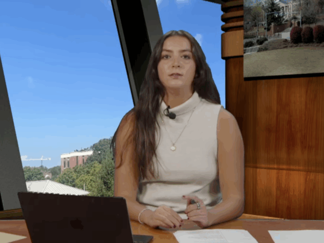 An anchor sitting behind a news desk