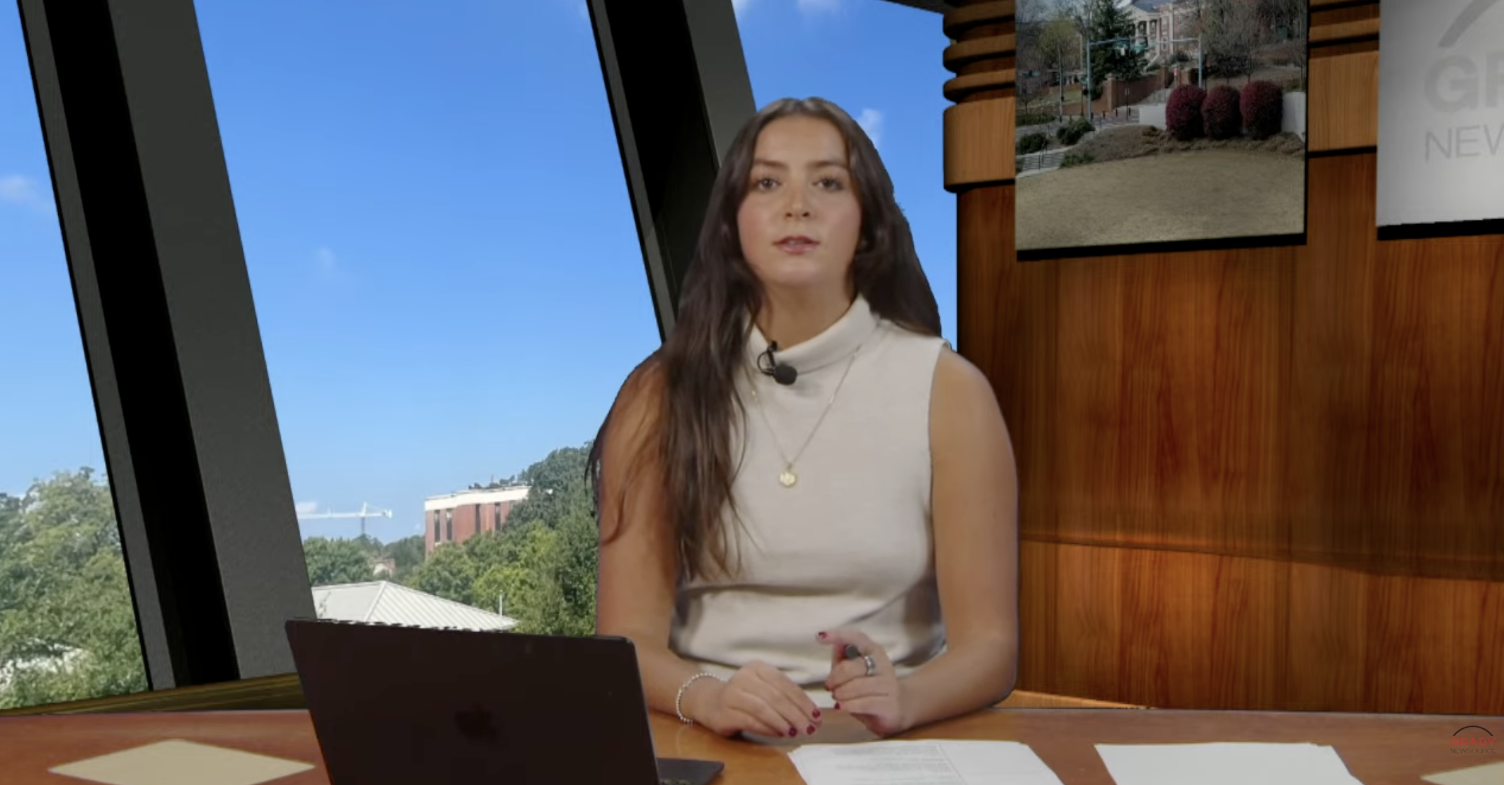 An anchor sitting behind a news desk
