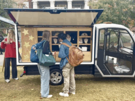 Two people ordering food from a merchandise truck