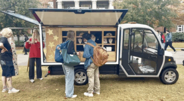 Two people ordering food from a merchandise truck