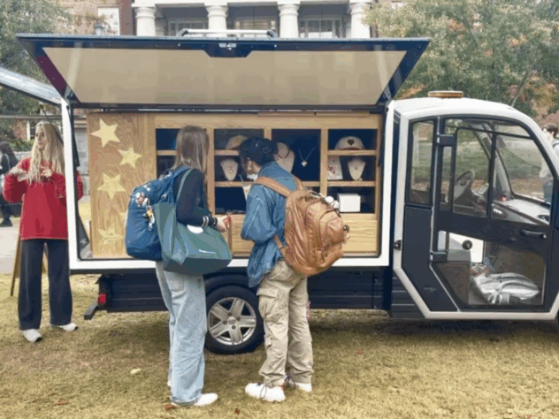 Two people ordering food from a merchandise truck