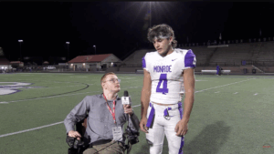 Sports reporter interviewing football player on the field