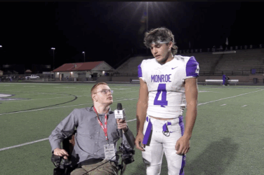 Sports reporter interviewing football player on the field