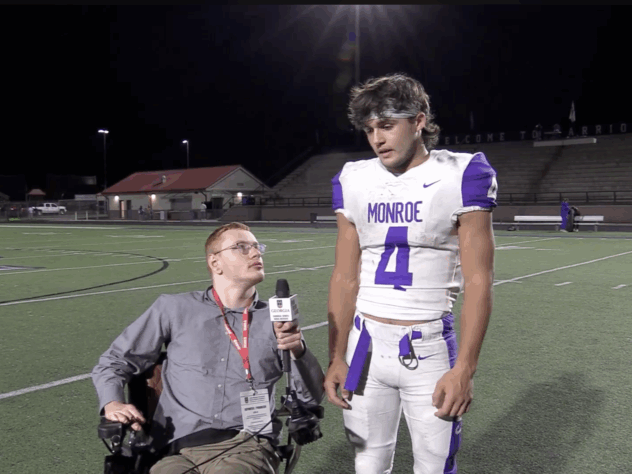 Sports reporter interviewing football player on the field