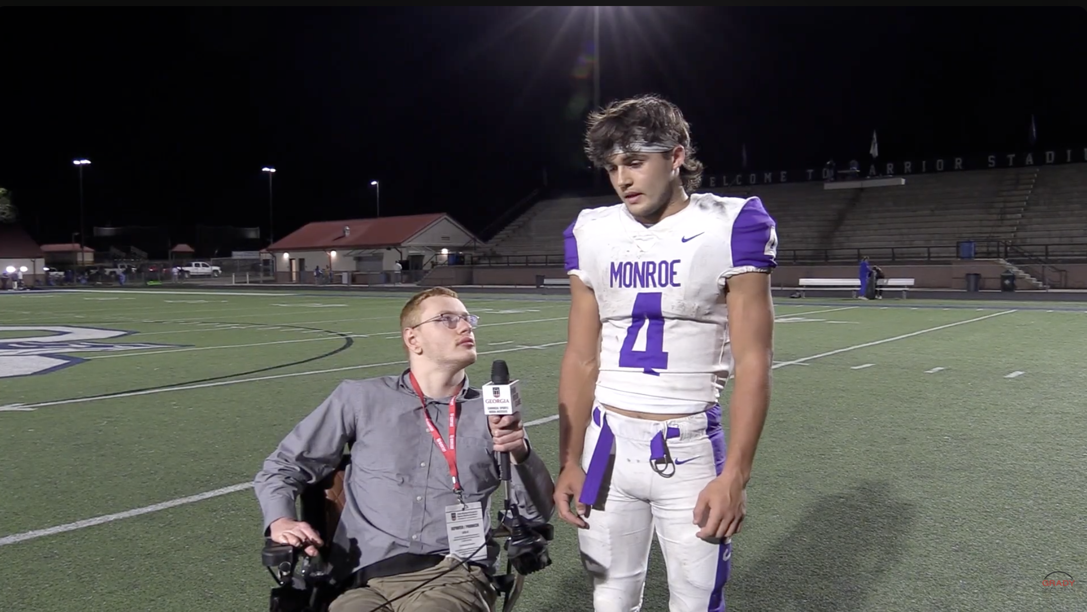 Sports reporter interviewing football player on the field