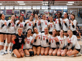 A volleyball team celebrates a title