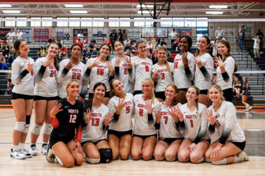 A volleyball team celebrates a title