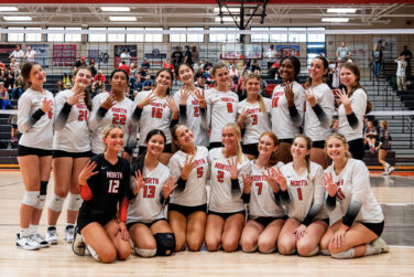 A volleyball team celebrates a title