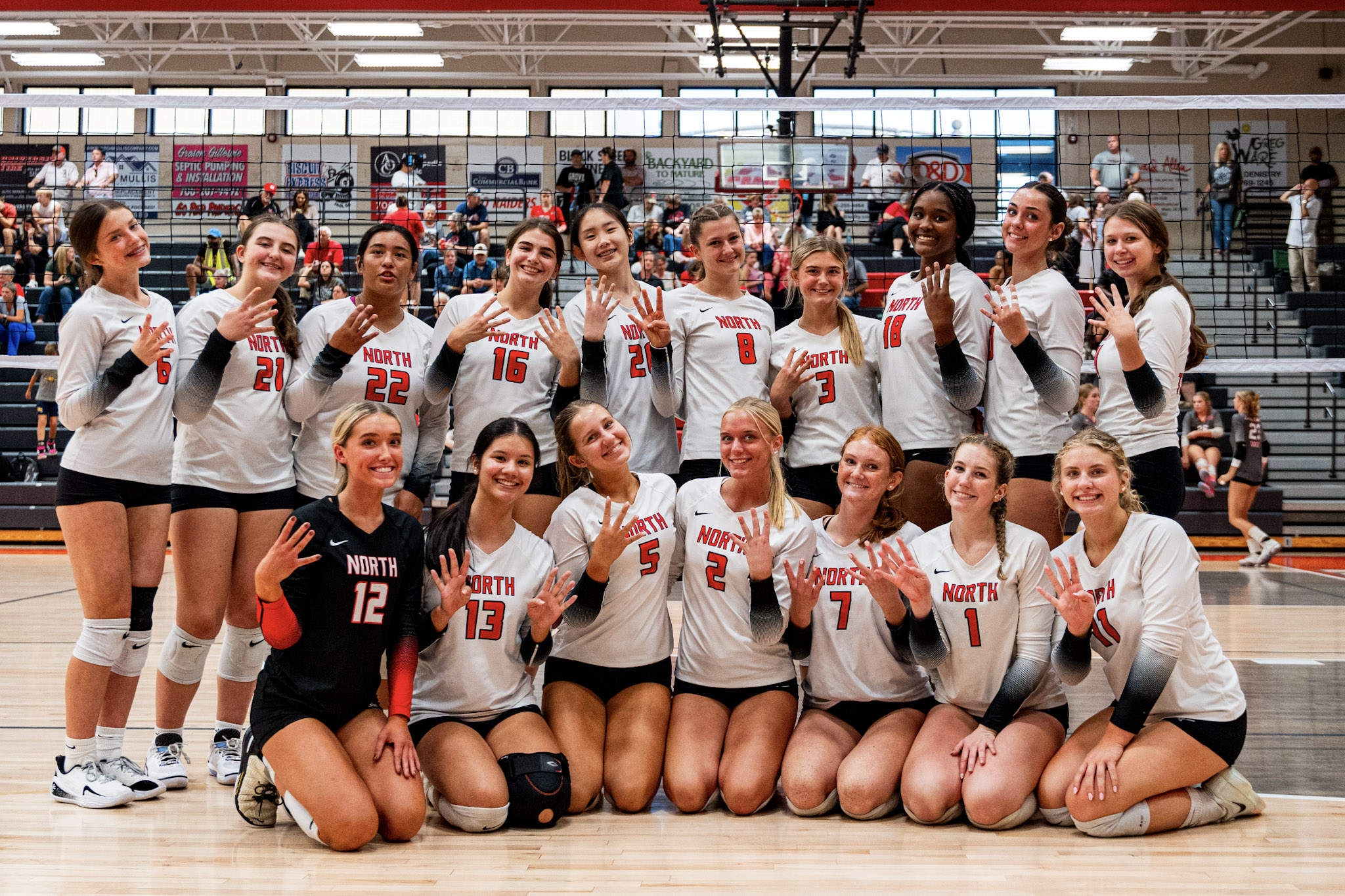 A volleyball team celebrates a title