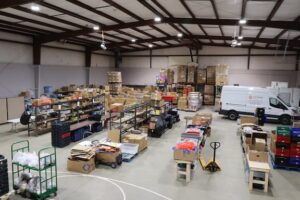A wide shot of a warehouse full of donations