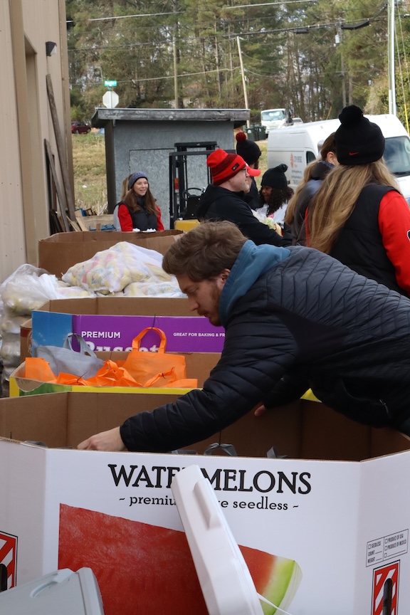People look inside bins of donations outside of a warehouse