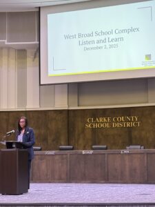 Woman stands at a podium in the Clarke County School District building on stage.