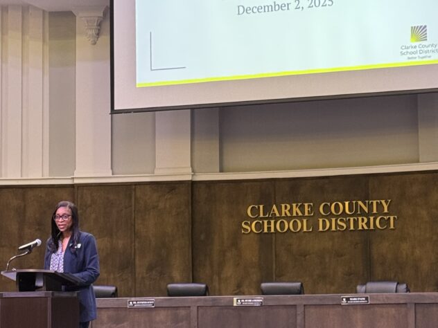 Woman stands at a podium in the Clarke County School District building on stage.