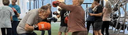 Woman and man boxing in a workout location