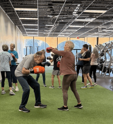 Woman and man boxing in a workout location