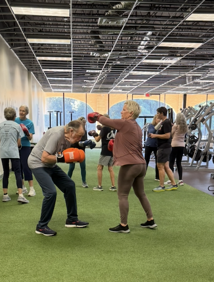 Woman and man boxing in a workout location