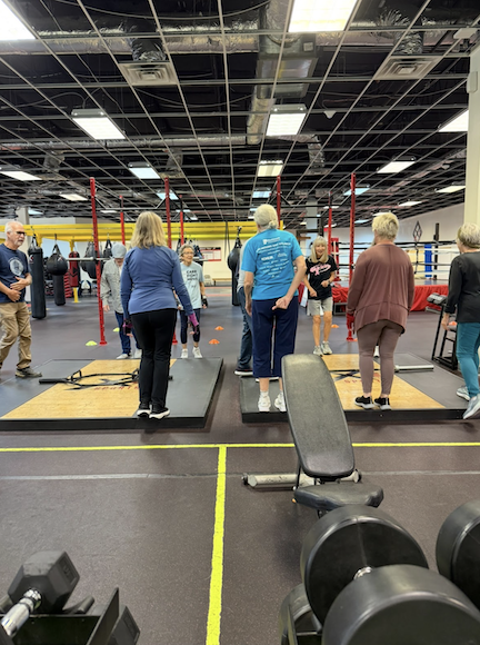 Group of people stand and start exercises at a workout center