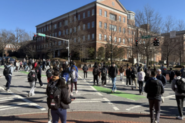 A large amount of students use crosswalks during a passing time in the class schedule.