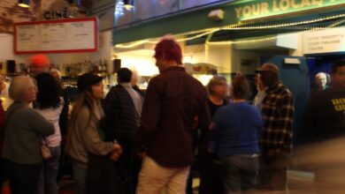 People stand outside talking on a street corner