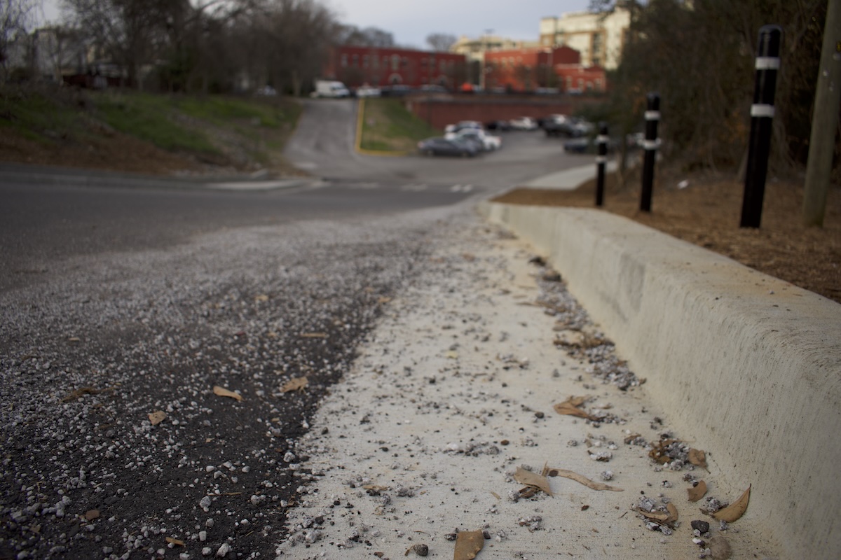 Gravel and other debris lines the curb near University of Georgia Police Department parking lot on Feb. 27, 2026
